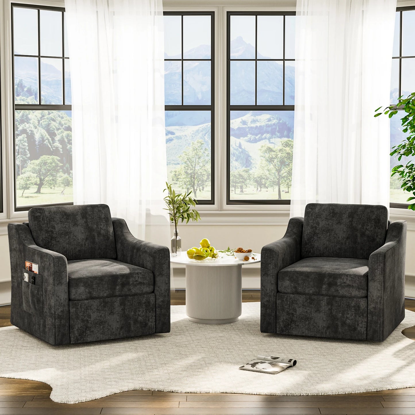 Two 360-degree swivel accent chairs in dark gray upholstery around a white round table in a bright living room.