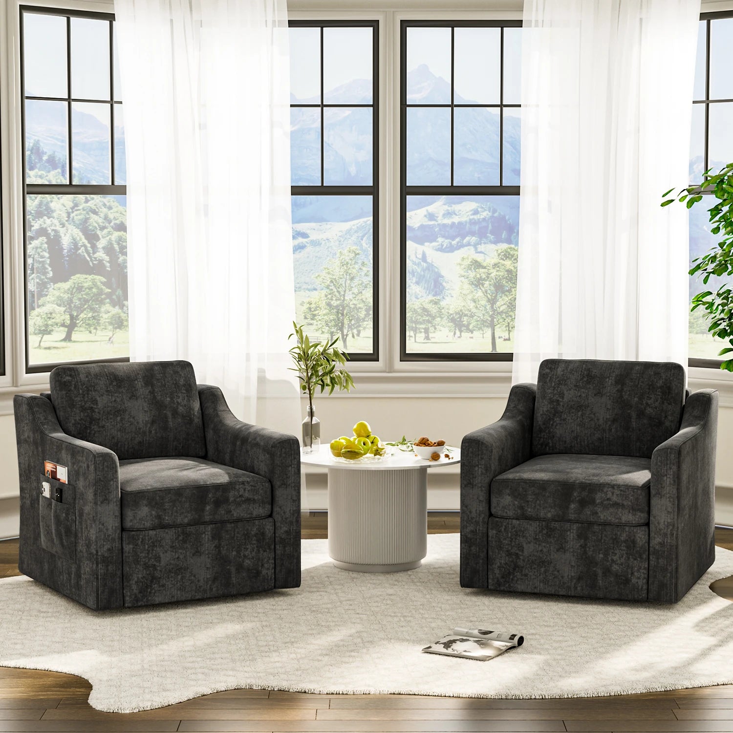 Two 360-degree swivel accent chairs in dark gray upholstery around a white round table in a bright living room.